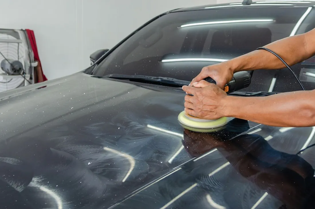 Illustrative photograph of hands polishing a car hood, not a coating result or client project