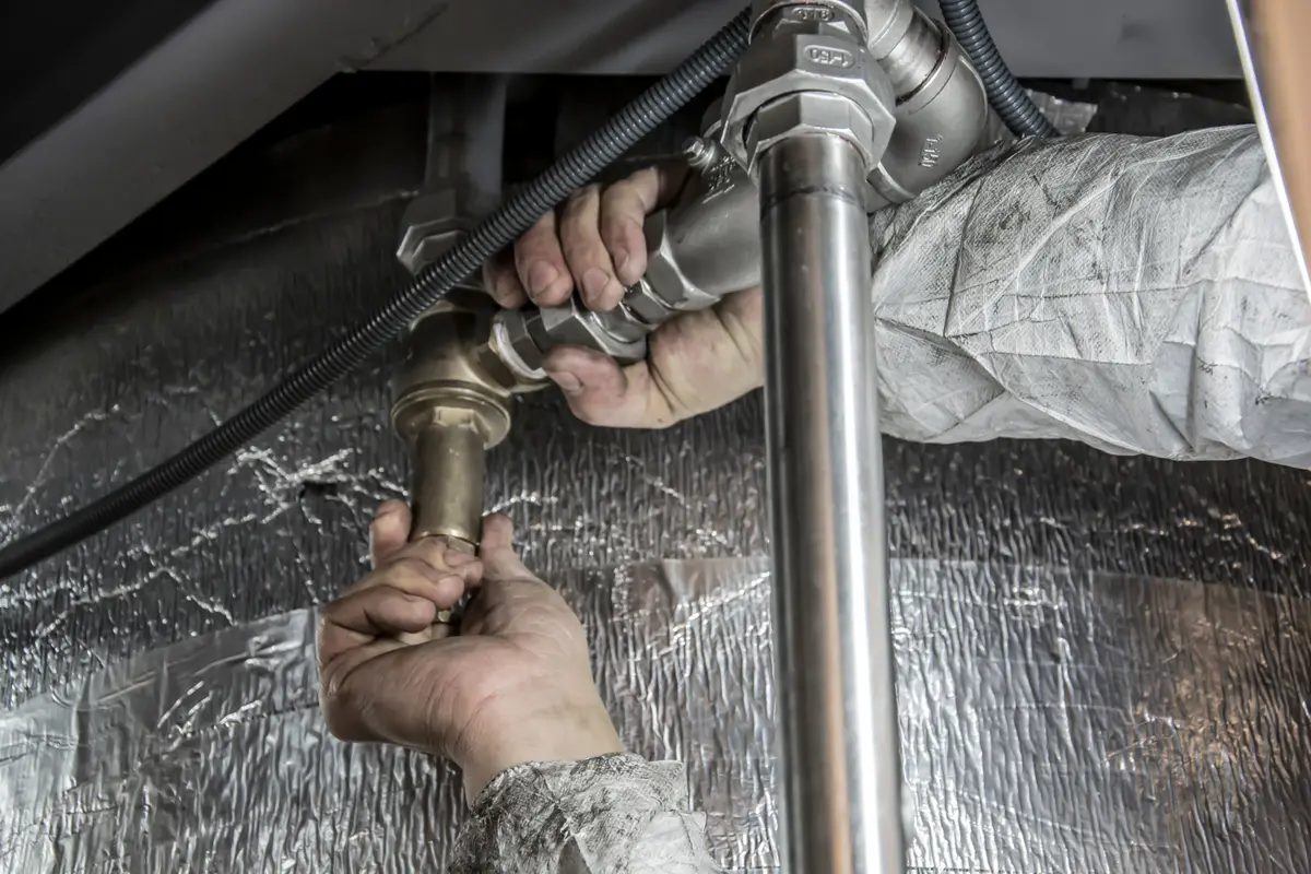 Illustrative stock photo of hands fitting metal plumbing connections